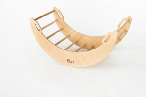 A wooden semicircular rocking toy with handles and horizontal rungs against a white background.
