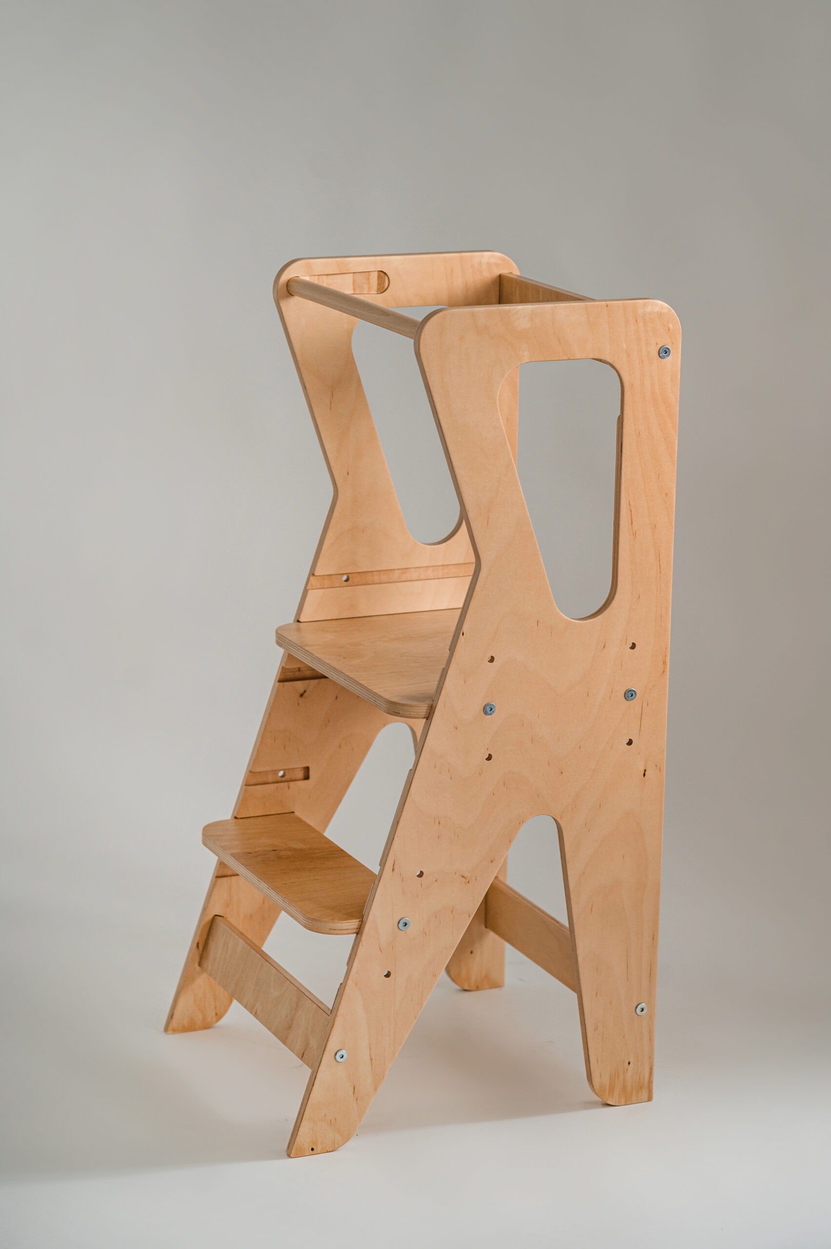 Lightweight wooden step stool with two steps and side cutouts, designed for children or kitchen use, against a plain background.